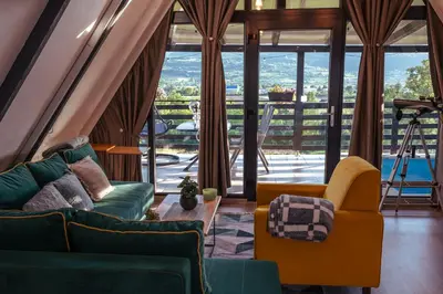 a living room with two couches and a table at Vikendica DORMINO in Bihać