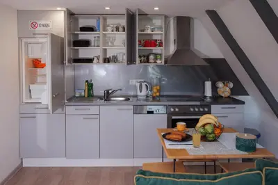 a kitchen with white cabinets and a table at Vikendica DORMINO in Bihać