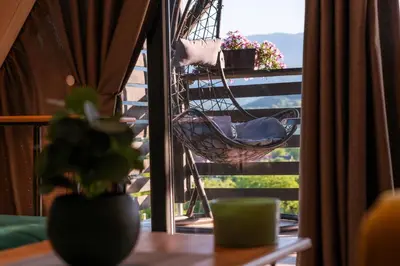 a hanging hammock on a balcony with a table at Vikendica DORMINO in Bihać