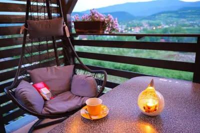 a table with a chair and a cup and a candle at Vikendica DORMINO in Bihać