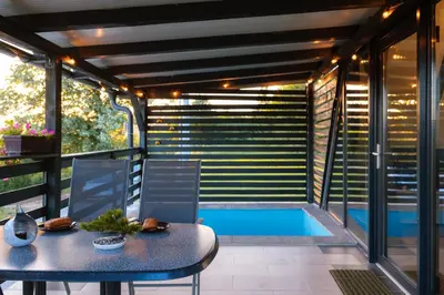 a patio with a table and chairs and a swimming pool at Vikendica DORMINO in Bihać