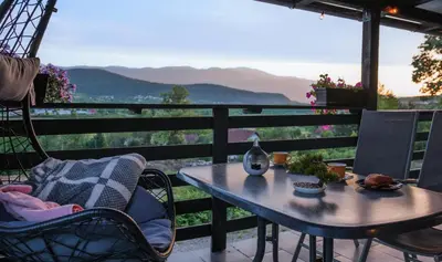 a table and chairs on a balcony with a view at Vikendica DORMINO in Bihać