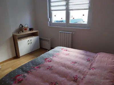 a bedroom with a pink bed and a window at Delta Lux Apartment in Banja Luka