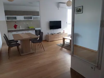 a kitchen and dining room with a table and chairs at Delta Lux Apartment in Banja Luka