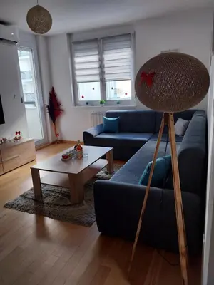 a living room with a blue couch and a table at Delta Lux Apartment in Banja Luka