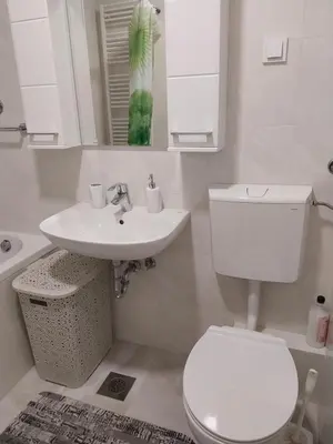a white bathroom with a toilet and a sink at Delta Lux Apartment in Banja Luka