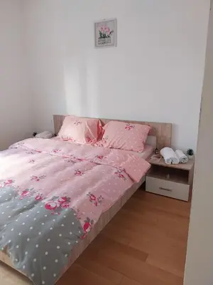 a bedroom with a bed with pink sheets and pink pillows at Delta Lux Apartment in Banja Luka