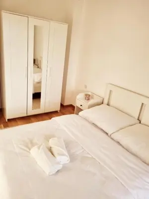 a white bed in a white bedroom with a mirror at Cozy Home Apartment Banja Luka in Banja Luka