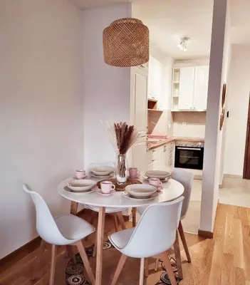 a white dining room with a white table and chairs at Cozy Home Apartment Banja Luka in Banja Luka