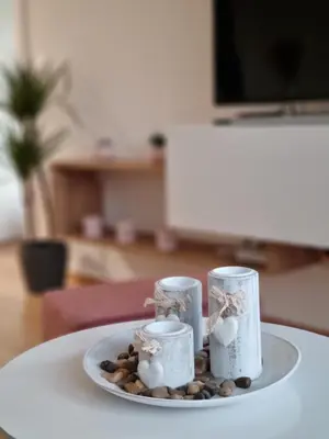 a plate with candles and rocks on a table at Cozy Home Apartment Banja Luka in Banja Luka
