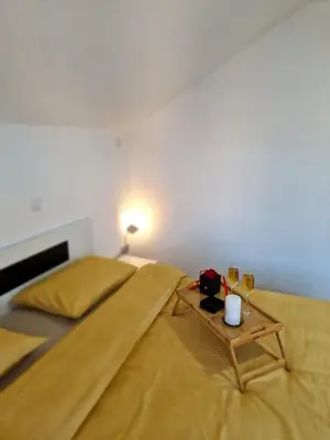 a bedroom with a bed and a table with wine glasses at Apartments Gradiska in Bosanska Gradiška