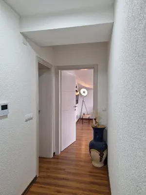 a hallway with a blue vase sitting on a wooden floor at Apartments Gradiska in Bosanska Gradiška