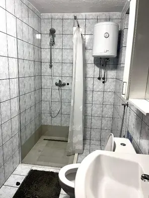 a bathroom with a shower and a toilet and a sink at Apart Cobras Jajce in Jajce