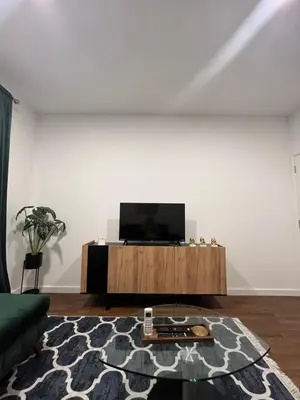 a living room with a flat screen tv on a cabinet at Apartman Lux Moli Banja Luka in Banja Luka