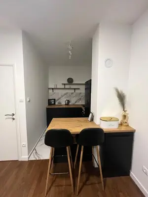 a kitchen with a wooden table and two chairs at Apartman Lux Moli Banja Luka in Banja Luka