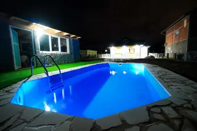 a blue swimming pool at night with lights at Apartment Lane in Bihać