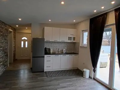 a kitchen with white cabinets and a refrigerator at Apartment Lane in Bihać