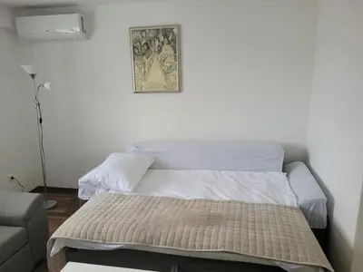 a bed in a room with a picture on the wall at Apartman Studenac in Kiseljak