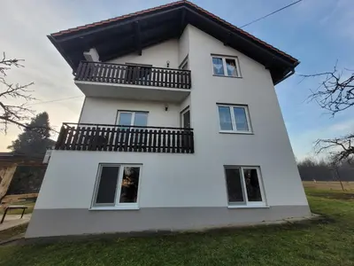 a white house with a balcony at Apartman Studenac in Kiseljak