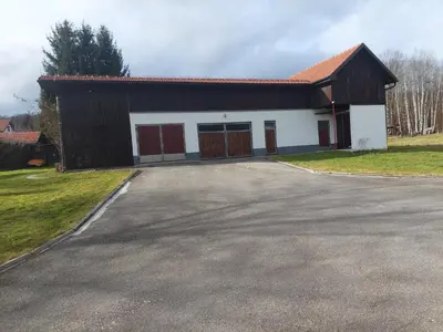 a building with two garage doors and a driveway at Apartman Studenac in Kiseljak