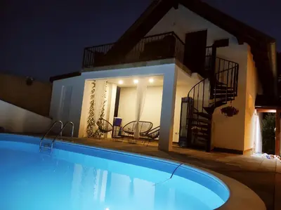 a swimming pool in front of a house at night at La Mia Casa in Bihać