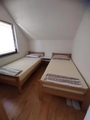 two beds in a small room with a window at La Mia Casa in Bihać