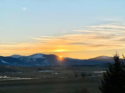 a sunset over the mountains with the sun in the sky at Kupres Desktop - mountain house in Kupres
