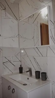 a white bathroom with a sink and a mirror at Apartman Barbi in Kupres