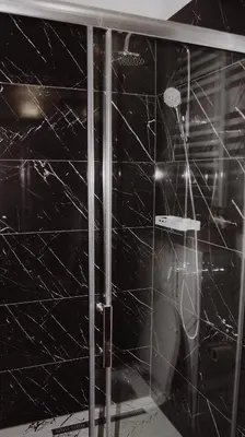 a bathroom with a shower with a black marble wall at Apartman Barbi in Kupres