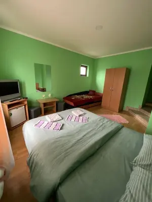 a large bed in a room with green walls at Ribarska Priča-Restoran pansion Prijedor in Prijedor