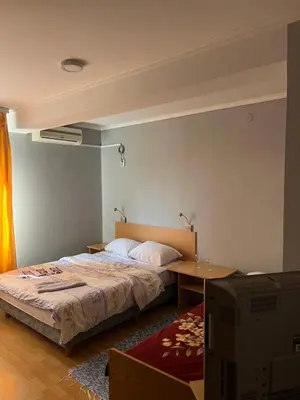 a bedroom with a bed and a table and a television at Ribarska Priča-Restoran pansion Prijedor in Prijedor