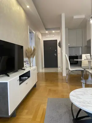 a living room with a television on a white cabinet at Infinity in Banja Luka