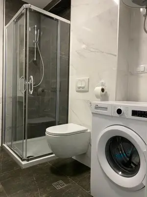 a bathroom with a toilet and a shower and a washing machine at Infinity in Banja Luka