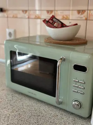 a green microwave on a counter with a bowl on top at Apartman Cypres in Kupres