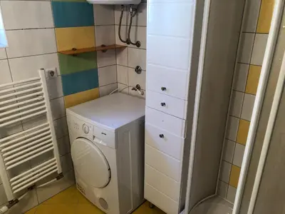 a small bathroom with a washing machine and a washer at Apartman Cypres in Kupres