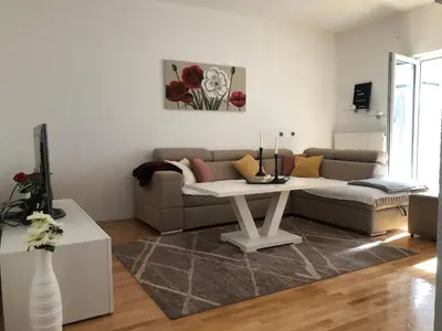 a living room with a couch and a table at Apartman Cypres in Kupres