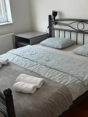 two beds with towels on them in a bedroom at Apartman Cypres in Kupres