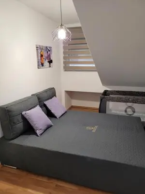 a bed with purple pillows in a room at Apartman MN Teslic in Teslić