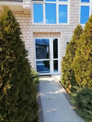 a front door of a house with trees in front at Apartman MN Teslic in Teslić