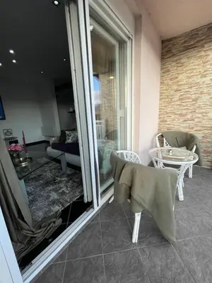 a room with a balcony with a table and chairs at Apartman MN Teslic in Teslić