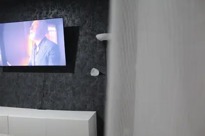 a television on a wall with a man on it at Apartman De Luxe in Tuzla