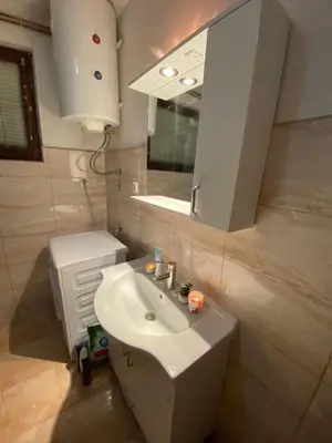 a bathroom with a white sink and a mirror at Apartman De Luxe in Tuzla