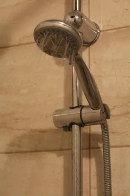 a shower with a shower head in a bathroom at Apartman De Luxe in Tuzla