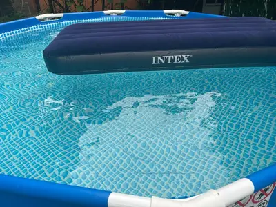 a blue swimming pool with an inflatable at Apartman De Luxe in Tuzla