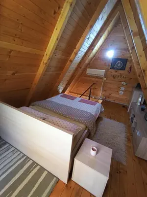 a bedroom with a bed in a attic at Vikendica Mimiena in Račić