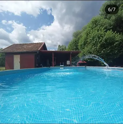 a large blue swimming pool in front of a house at Vikendica Mimiena in Račić