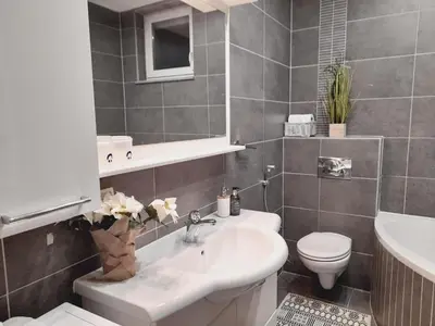 a bathroom with a white sink and a toilet at Apartman Jasmina in Bihać