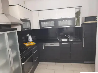 a kitchen with black and white cabinets and a sink at Apartman Jasmina in Bihać