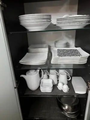 a cabinet filled with dishes and plates and utensils at Apartman Jasmina in Bihać