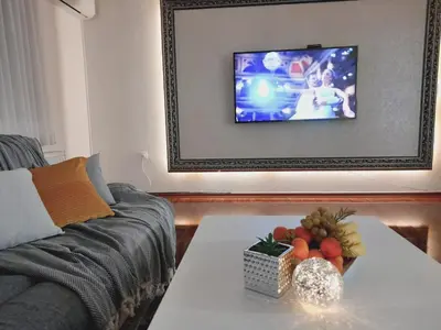 a living room with a couch and a table with a television at Apartman Jasmina in Bihać